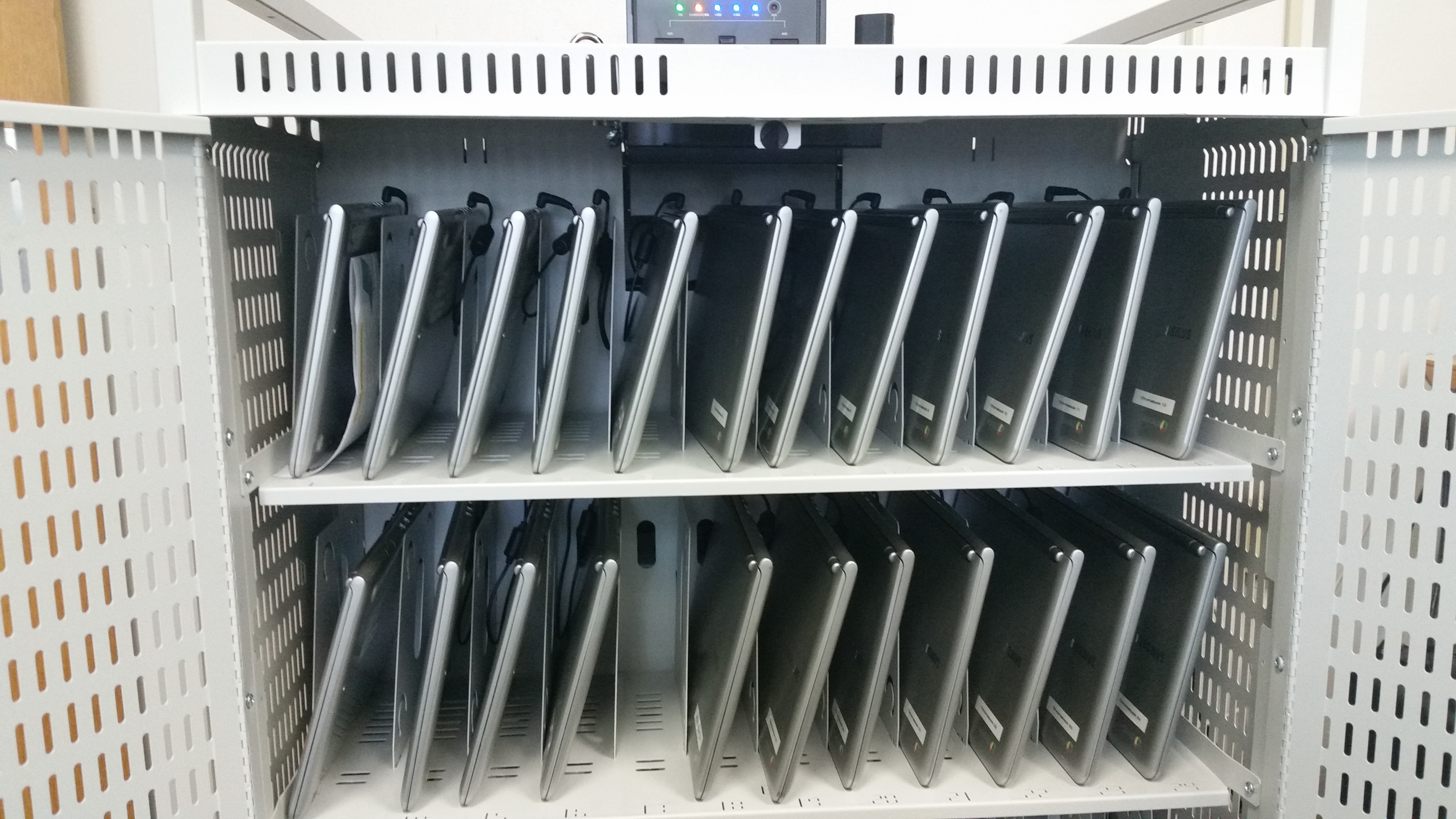 metal cabinet with chromebooks in vertical slots