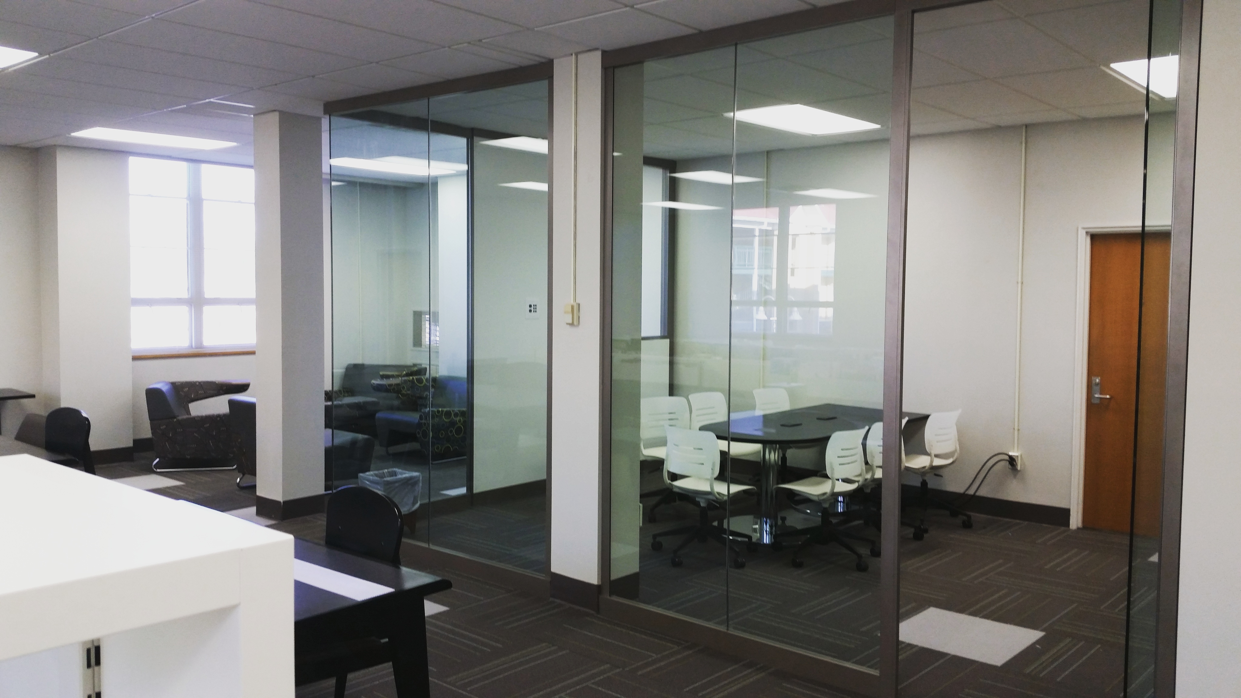 Nash Library's glass-walled classroom in music pocket library with table and chairs