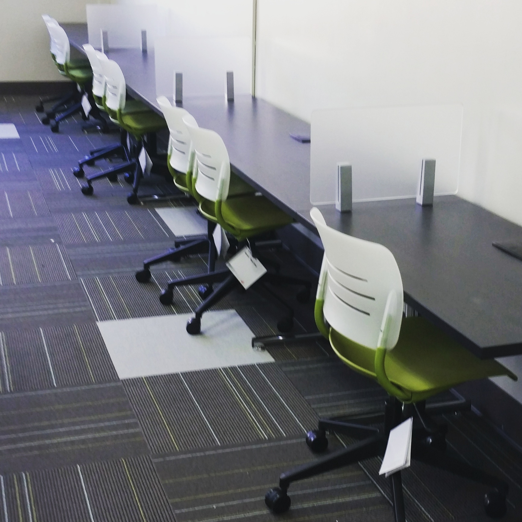 row of desks with rolling chairs