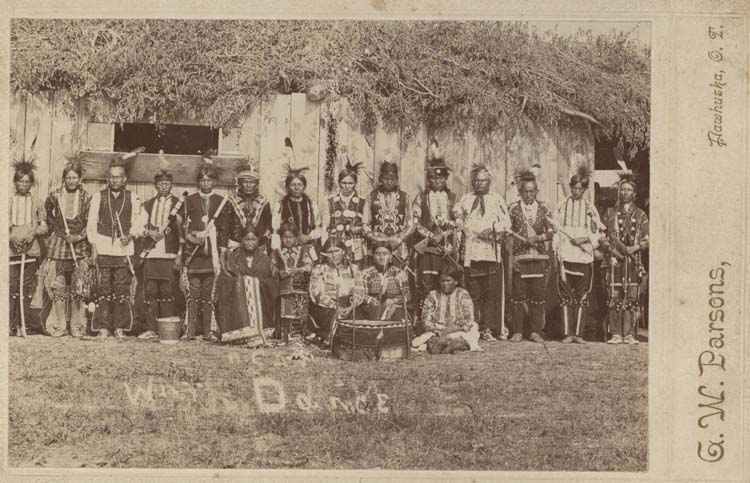 A group of American Indians in costume with musical instruments